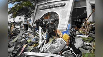 Residentes afectados por el terremoto rescatan artÃculos utilizables de un mercado colapsado en Palu. Hay más vigilancia para evitar los saqueos.